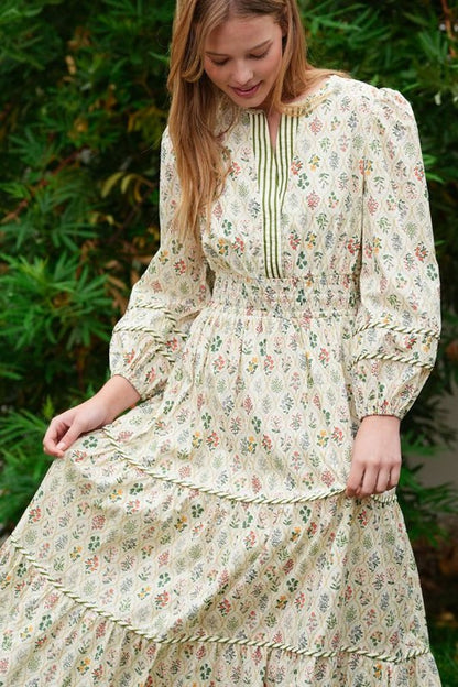 ModestAndDevoted novelty print maxi dress with pockets and detailed trim, flowing design, and vibrant pattern.