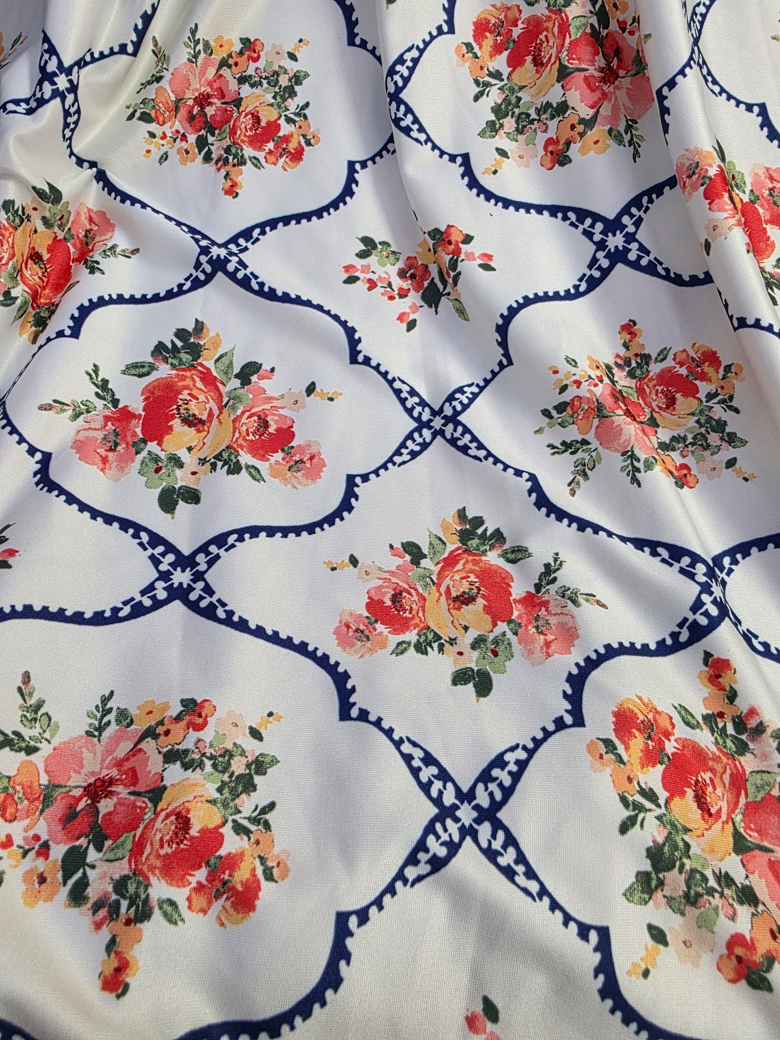 Pink floral lattice print dress with a tie waist from ModestAndDevoted, featuring a flattering silhouette and vibrant floral pattern.