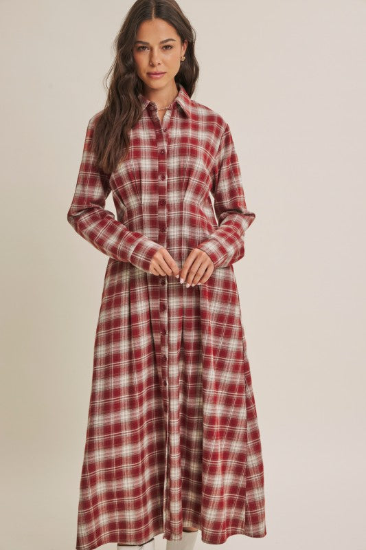 Brick-colored ModestAndDevoted Perfection Plaid Cotton Shirt Dress hanging on a hanger, showcasing its classic plaid pattern and button details.