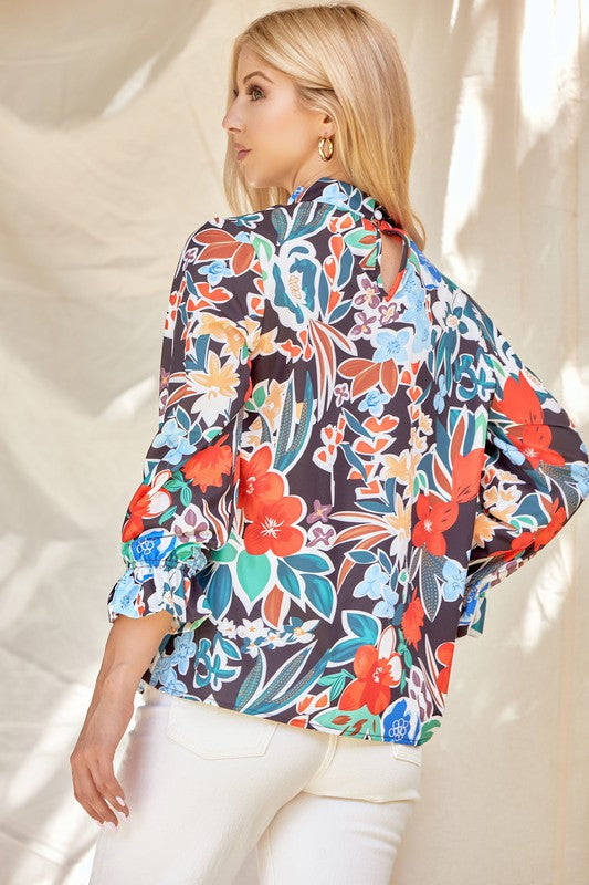 Floral ruffle neck blouse from ModestAndDevoted featuring lightweight fabric and feminine ruffle details, perfect for casual or dressy wear.