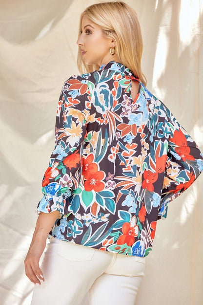 Floral ruffle neck blouse from ModestAndDevoted featuring lightweight fabric and feminine ruffle details, perfect for casual or dressy wear.