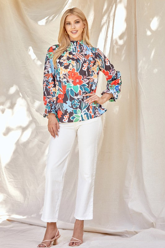 Floral ruffle neck blouse from ModestAndDevoted, stylish shirt with feminine ruffle details and vibrant floral pattern.