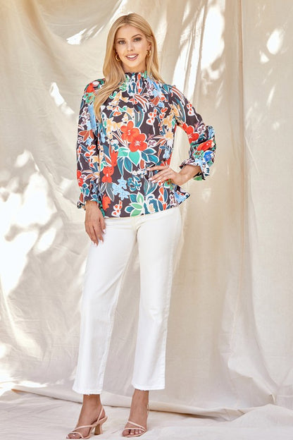 Floral ruffle neck blouse from ModestAndDevoted, stylish shirt with feminine ruffle details and vibrant floral pattern.