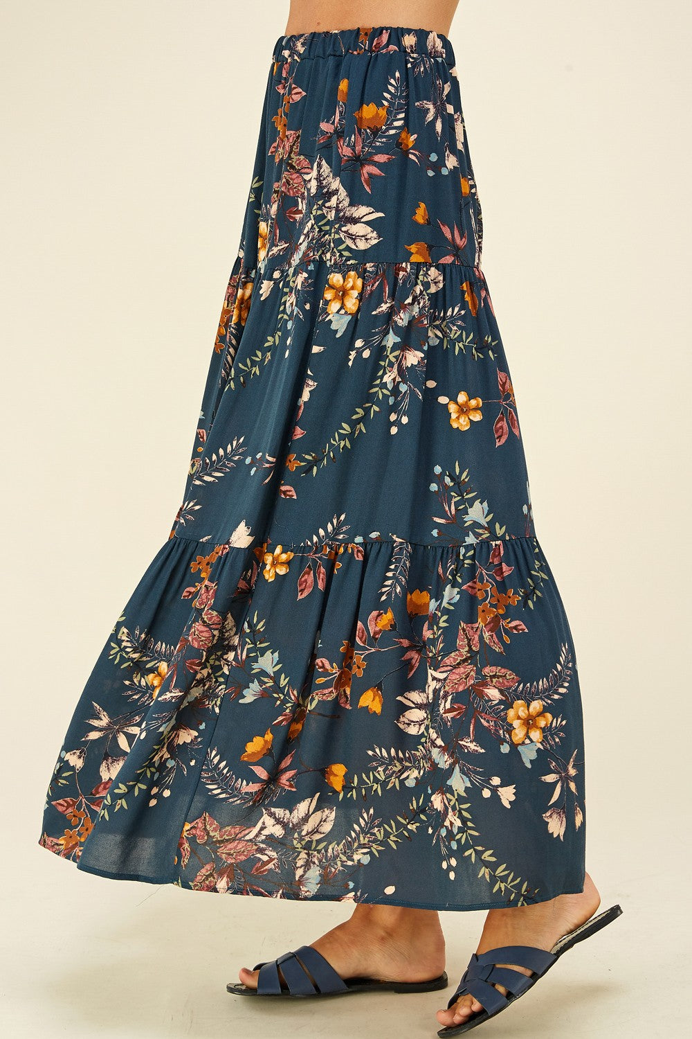 Navy floral three-tier maxi skirt by ModestAndDevoted, flowing fabric with layered tiers and a floral pattern.