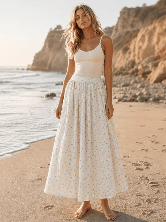 Women's blue floral print maxi skirt with elastic waist from ModestAndDevoted, displayed on a hanger with a flowy fabric.