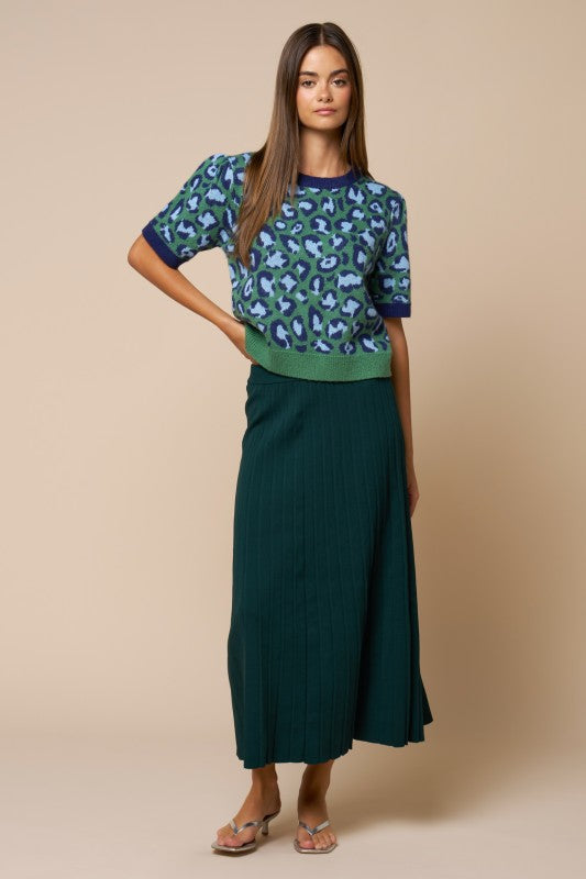 Forest teal high-waisted pleated midi skirt from ModestAndDevoted, shown with a ribbed boat neck dolman sleeve sweater.