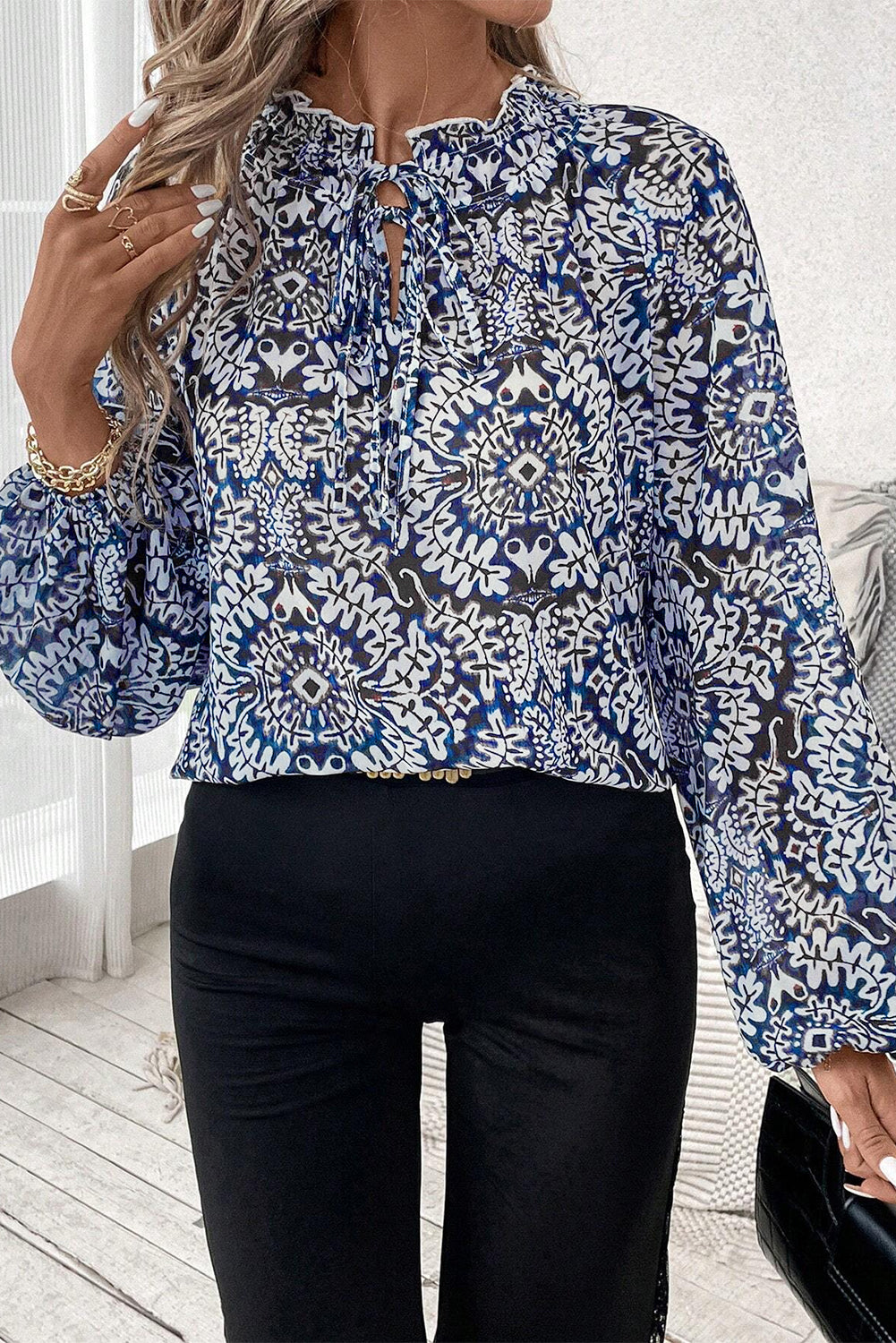 Blue tribal print lace-up blouse with puff sleeves and frilled neckline from ModestAndDevoted, made of polyester.