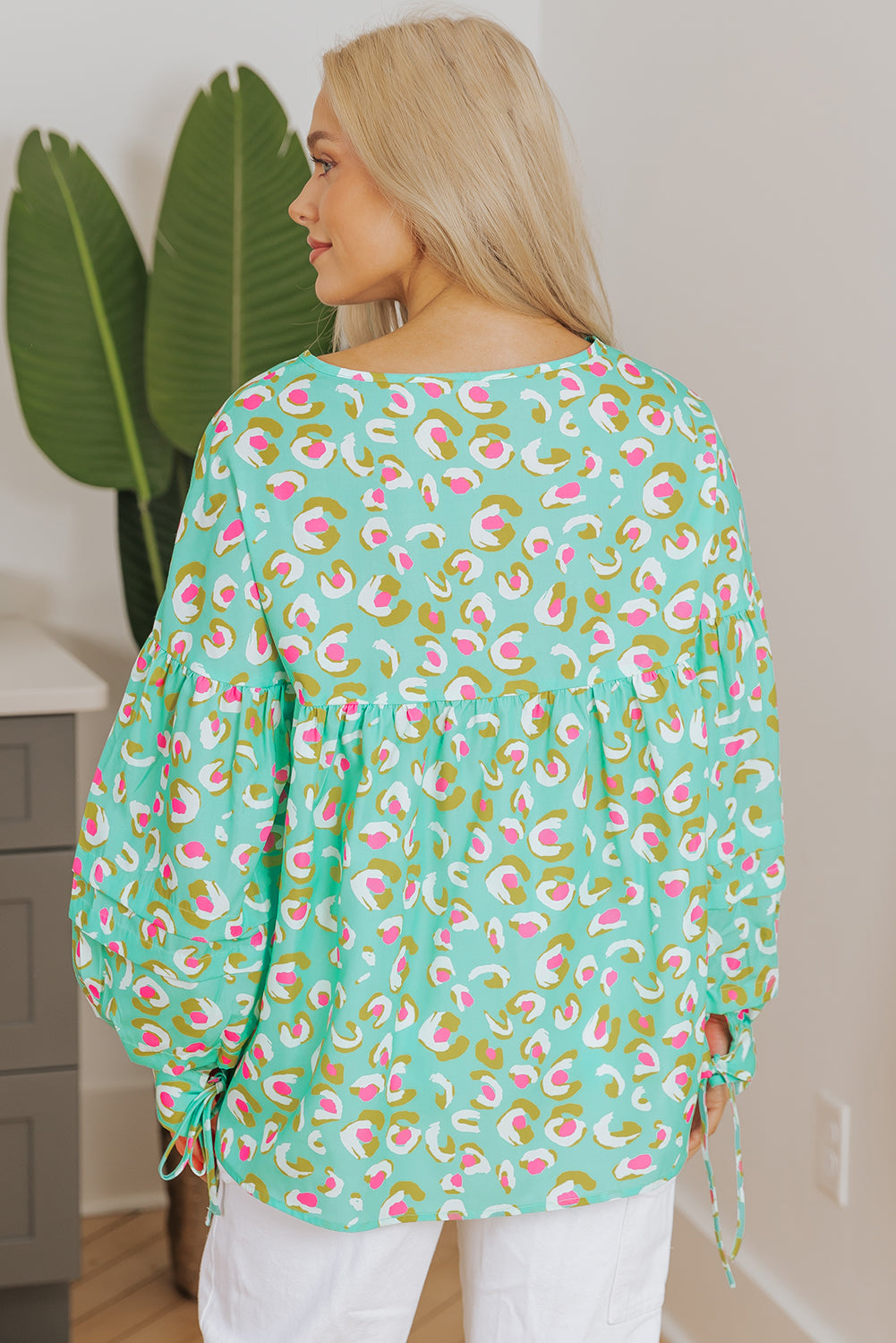 Green abstract printed babydoll blouse with lantern sleeves and lace-up front, made of polyester, by ModestAndDevoted.