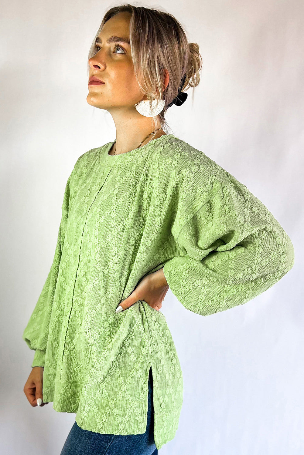 Light green textured crew neck blouse with side split, made of polyester and elastane, by ModestAndDevoted.