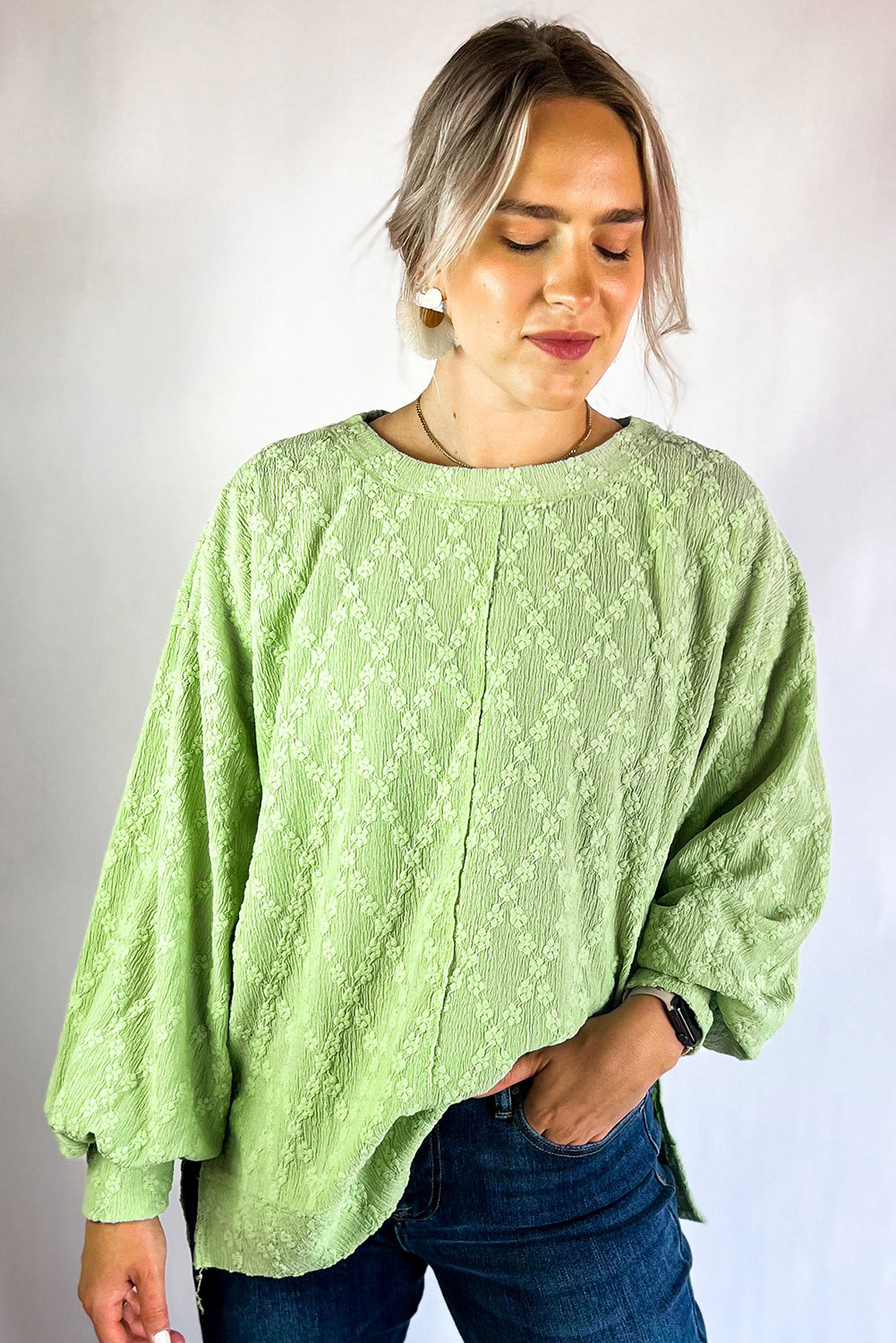 Light green textured crew neck blouse with side split, made of polyester and elastane, by ModestAndDevoted.