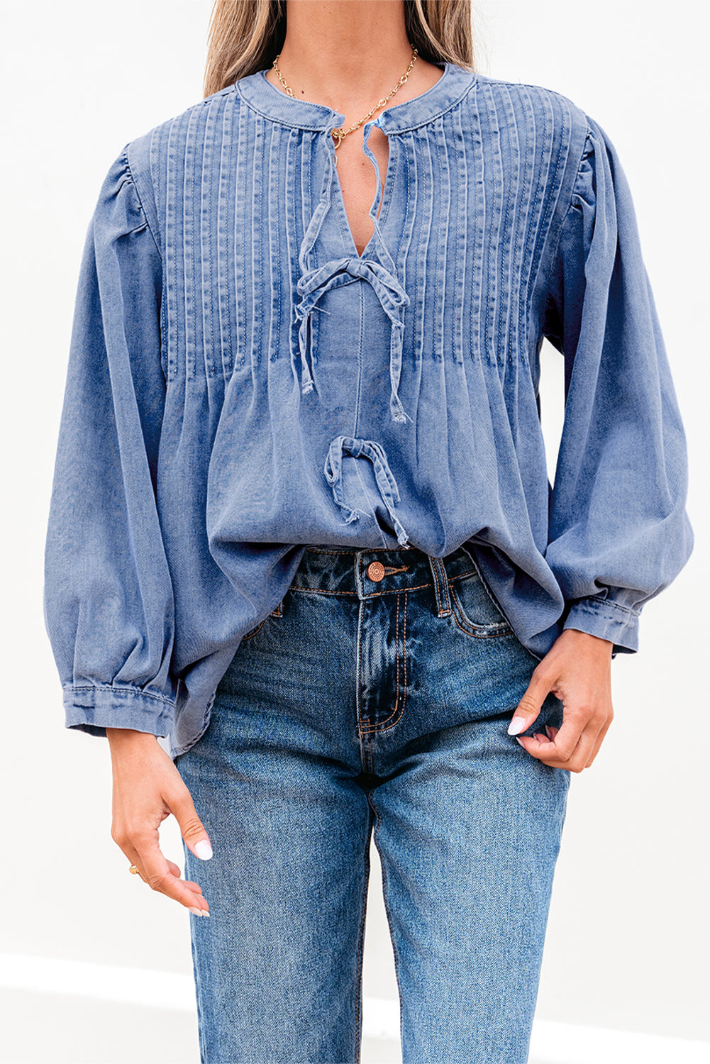 Myosotis denim puff sleeve top with front pintuck detailing and bow tie, from ModestAndDevoted, made of cotton-polyester blend.