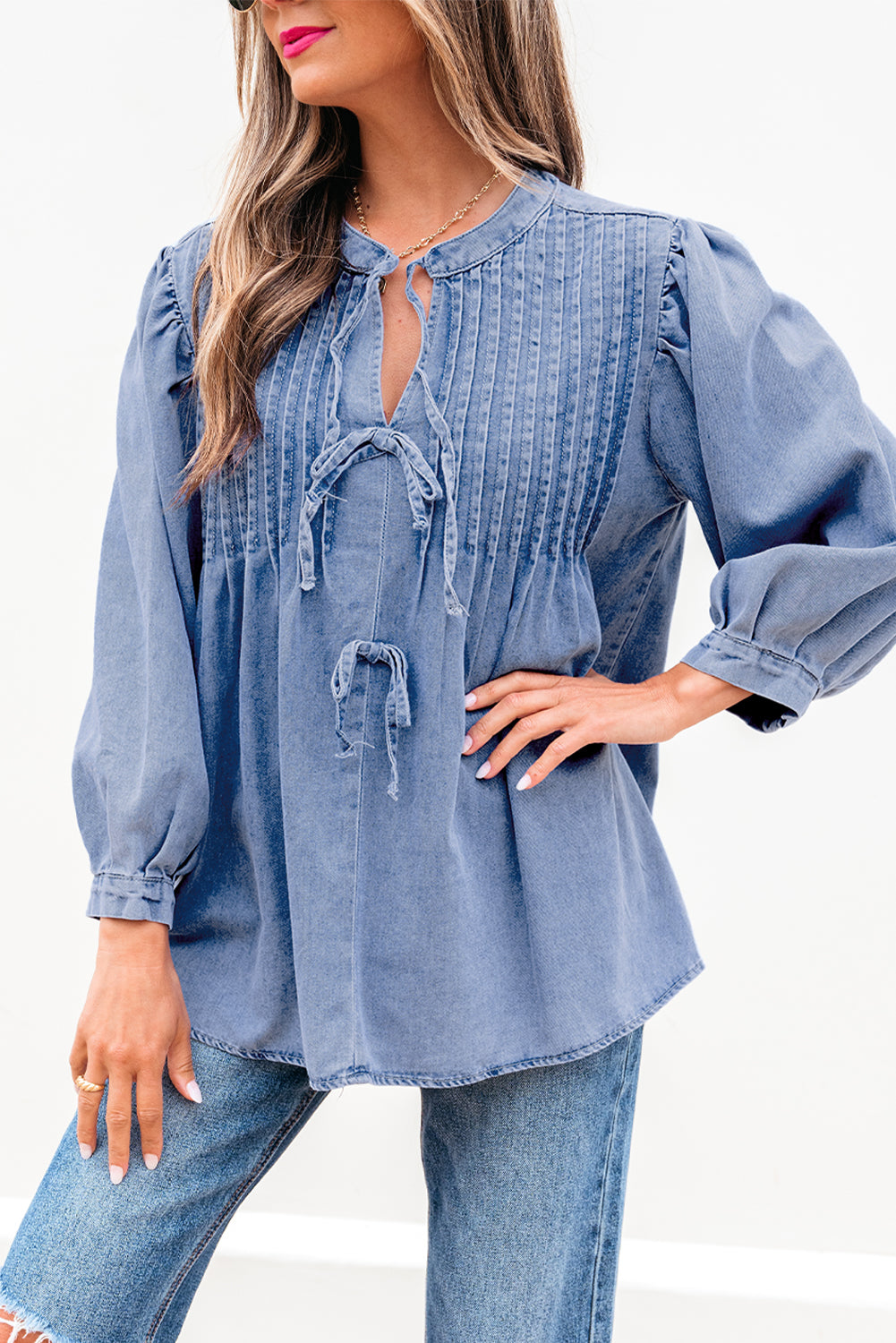 Myosotis denim puff sleeve top with front pintuck and bow tie detail, from ModestAndDevoted, made of cotton and polyester blend.