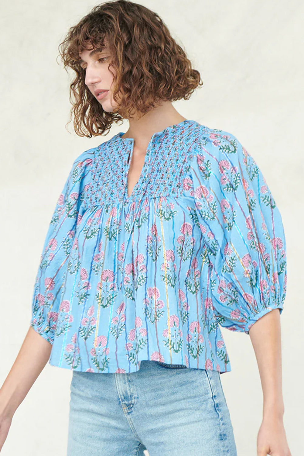Sky blue floral striped print blouse with shirred yoke and split neck, made by ModestAndDevoted, shown on a hanger.