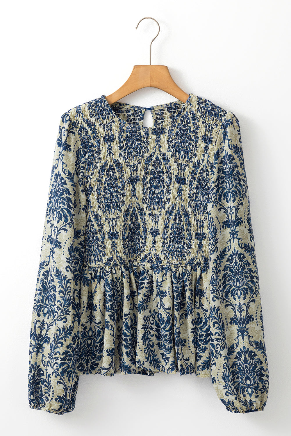 Sky blue boho printed balloon sleeve smocked peplum blouse from ModestAndDevoted, featuring a relaxed fit and floral pattern.