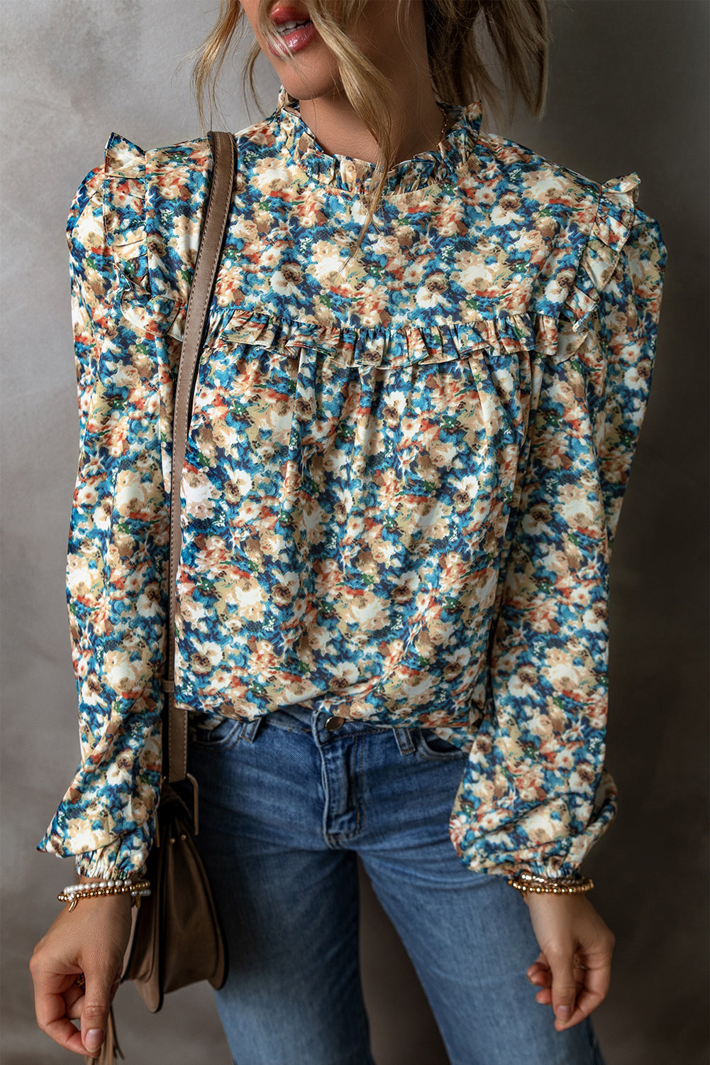 Sky blue floral print blouse with frilled mock neck and puff sleeves, made by ModestAndDevoted, displayed on a hanger.