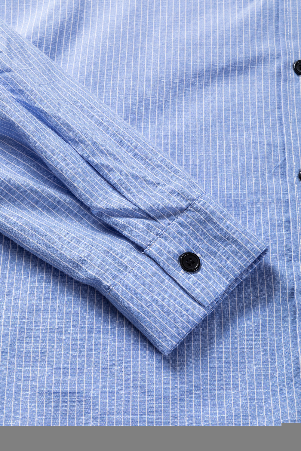 Sky blue stripe long blouse with roll-tab sleeves and front pockets from ModestAndDevoted, made of polyester and cotton blend.