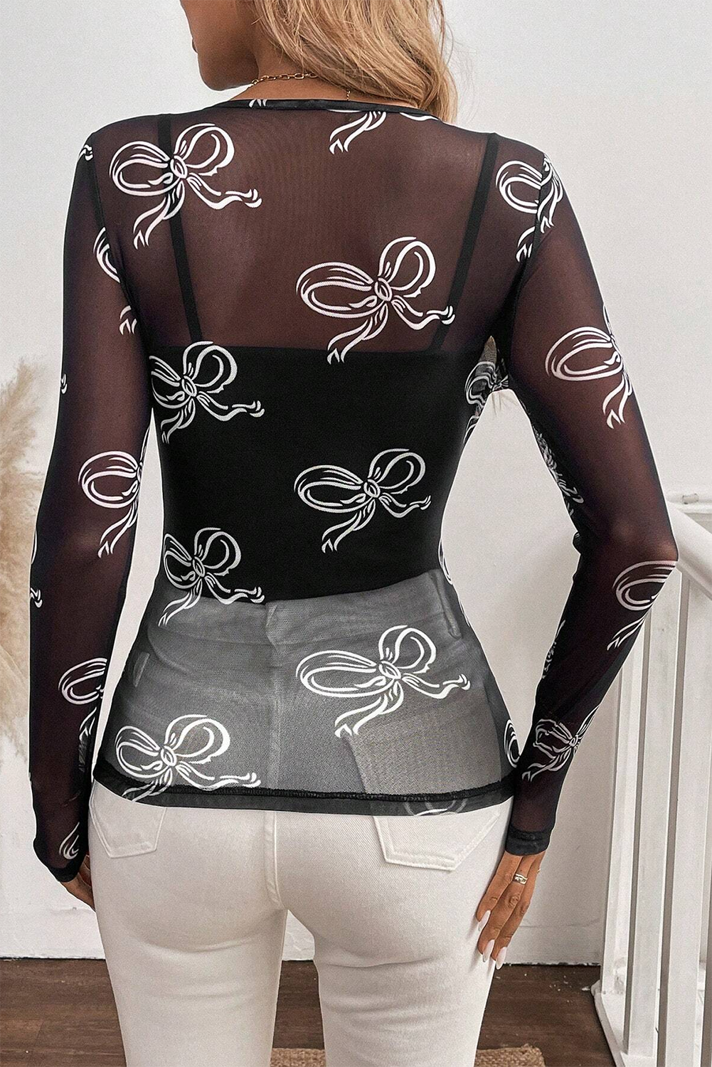 Pink round neck long sleeve mesh top with bow print from ModestAndDevoted, featuring a fitted style and sheer fabric.