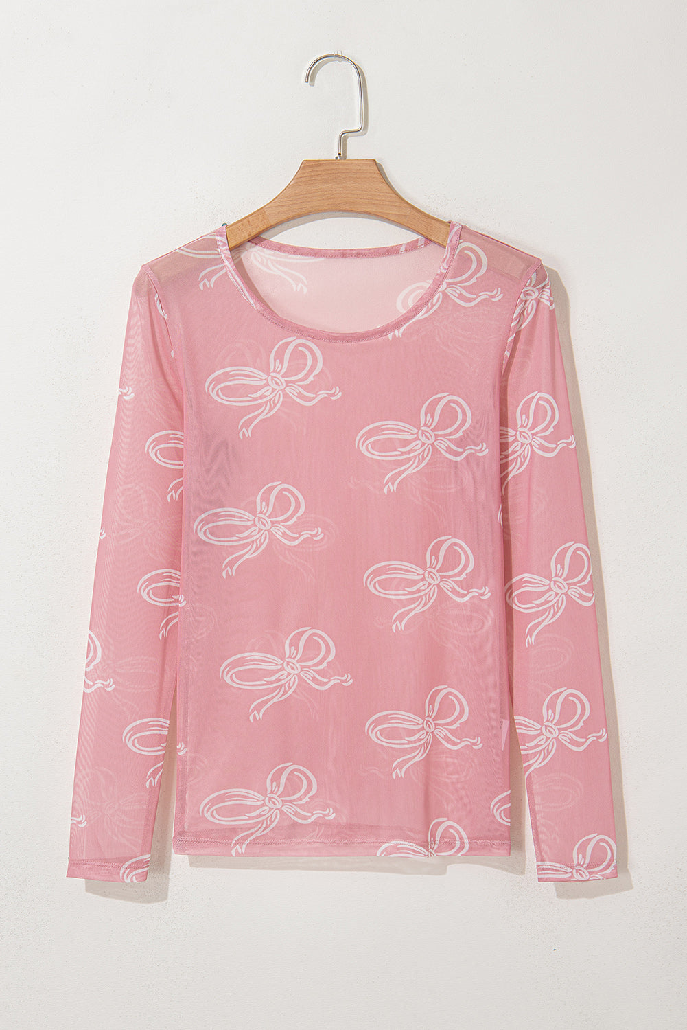 Pink round neck mesh top with bow print and long sleeves from ModestAndDevoted, featuring a lightweight polyester and elastane blend.