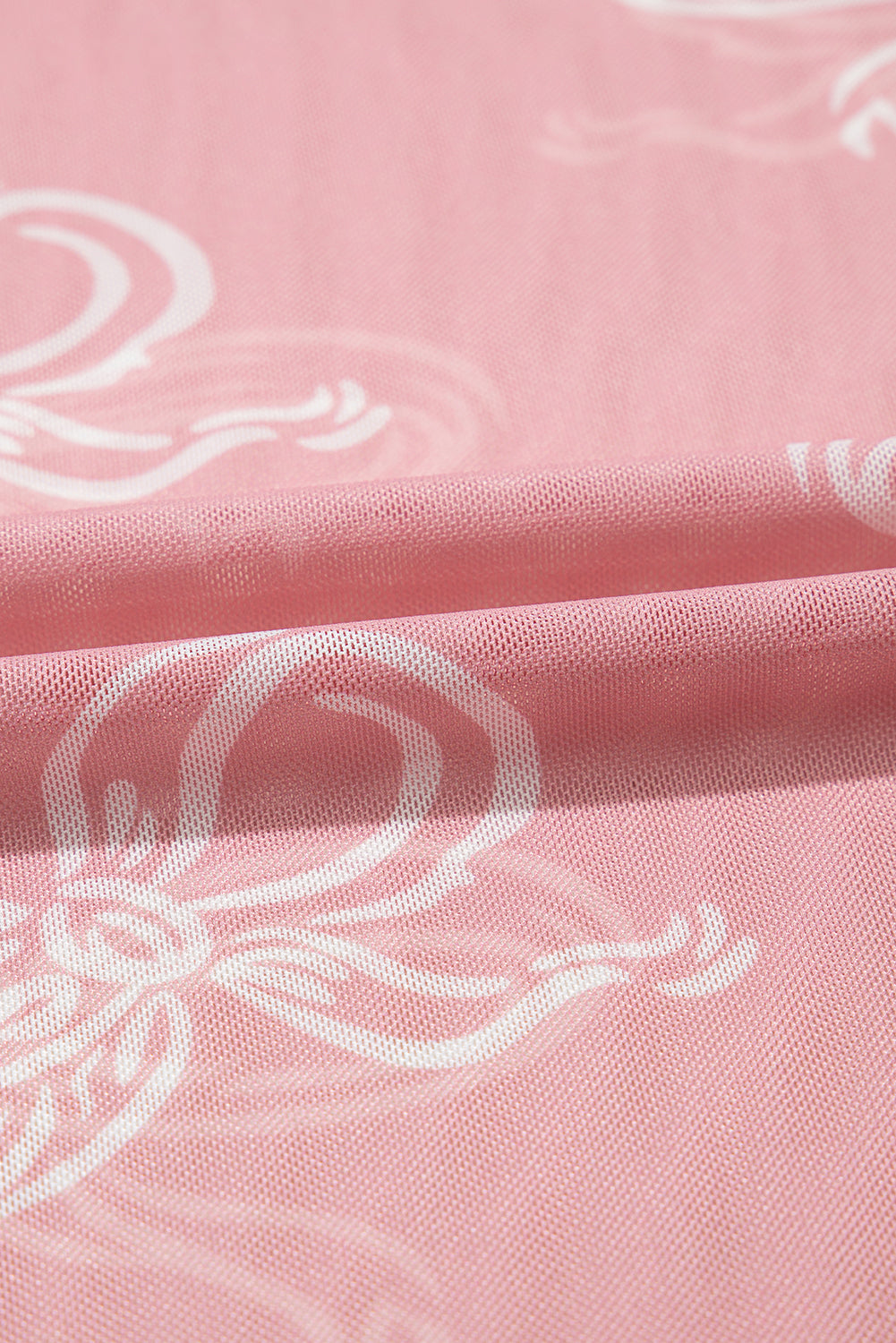 Pink round neck long sleeve mesh top with bow print from ModestAndDevoted, featuring a fitted design and sheer fabric.