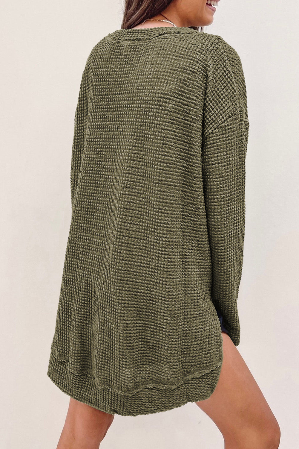 Green waffle knit oversized long sleeve top with high slits by ModestAndDevoted, featuring a relaxed fit and textured fabric.