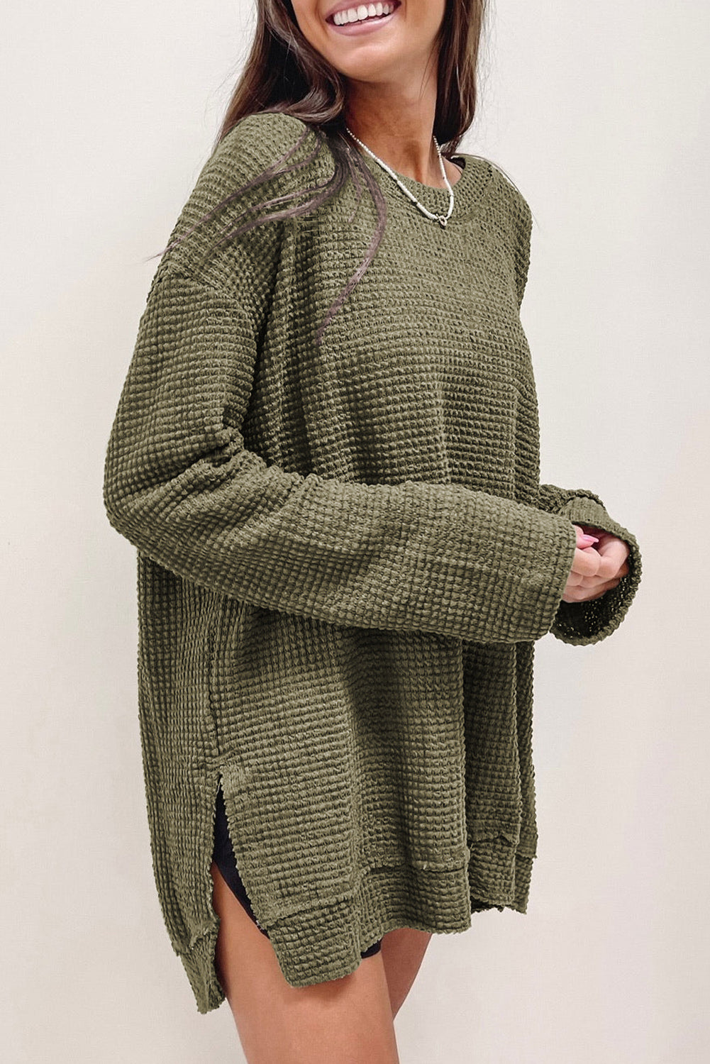 Green waffle knit oversized long sleeve top with high slits from ModestAndDevoted, featuring a relaxed fit and textured fabric.