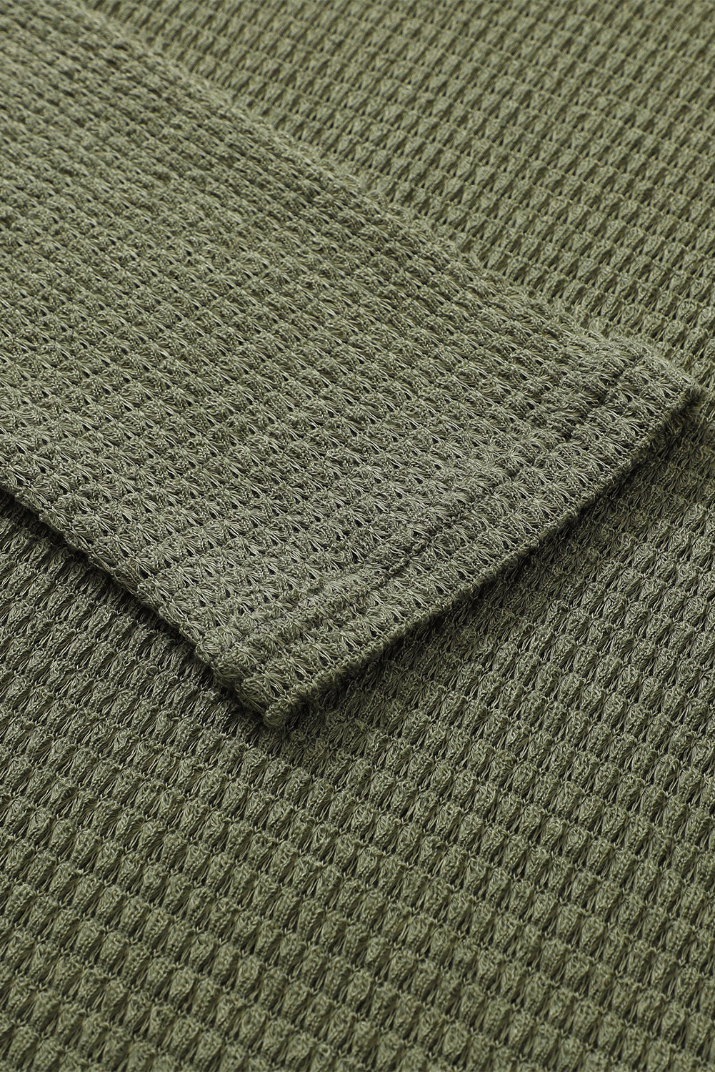 Green waffle knit oversized long sleeve top with high slits from ModestAndDevoted, featuring a relaxed fit and textured fabric.