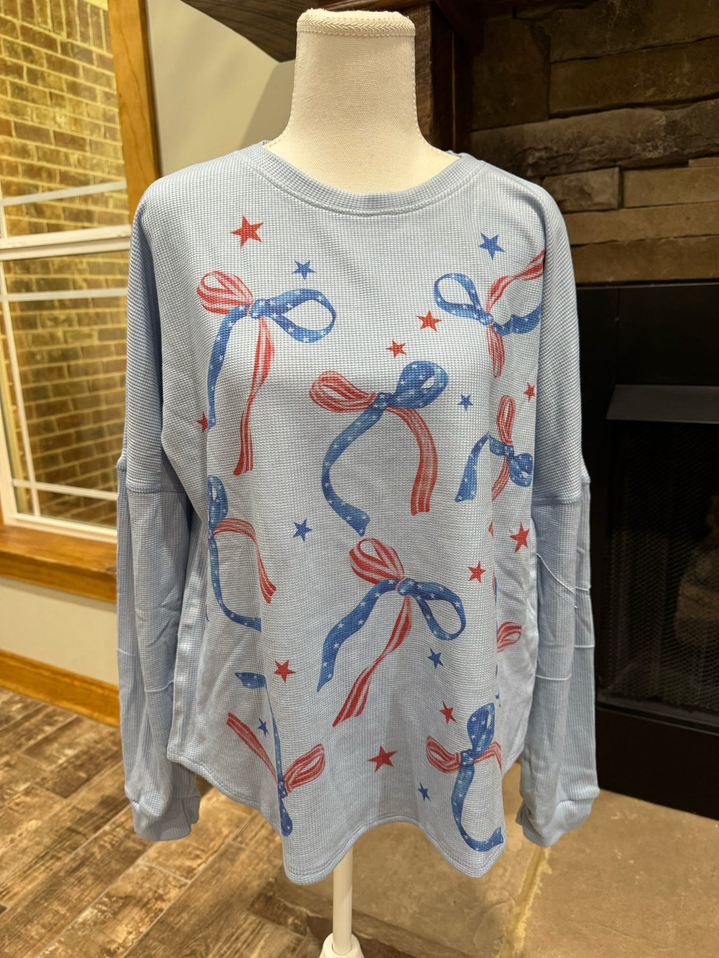 Blue patriotic bow long sleeve top by ModestAndDevoted, featuring a comfortable fit and stylish design for everyday wear.