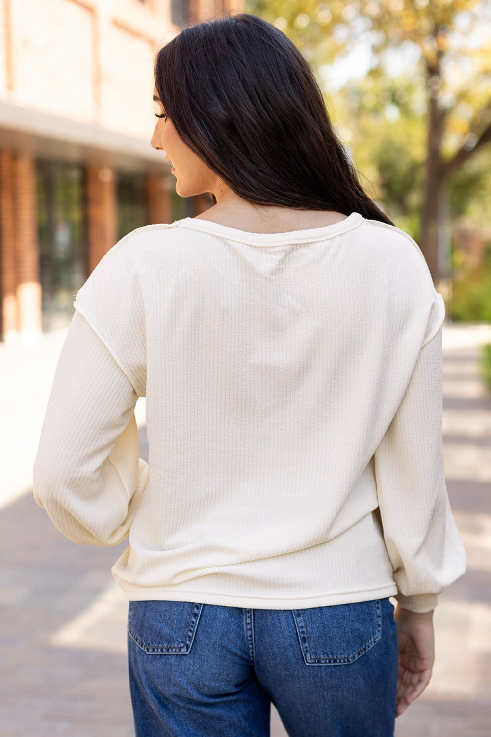 White corded knit patchwork drop sleeve top by ModestAndDevoted, featuring exposed seams and long sleeves, made of polyester and elastane.