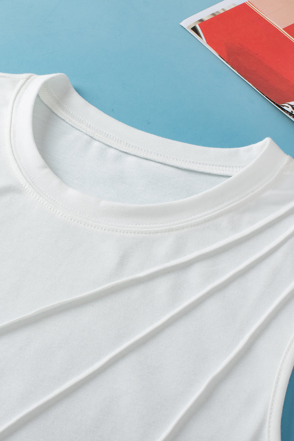 White crew neck pleated tank top from ModestAndDevoted, made of polyester, cotton, and elastane, displayed on a plain background.