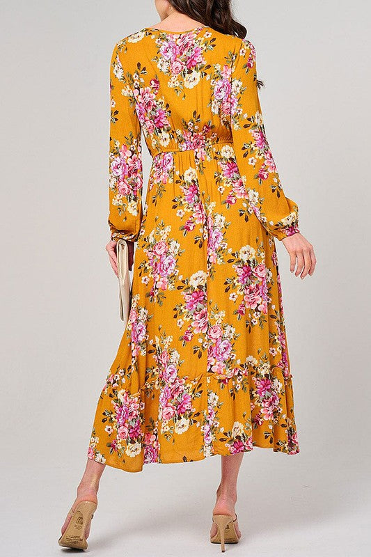 Long sleeve floral maxi dress in mustard color by Rousseau, featuring an elastic waist and flowing fabric.