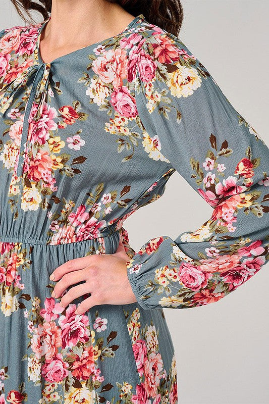 Long sleeve floral maxi dress in sage with elastic waist from Rousseau, featuring a flowing design and vibrant floral pattern.