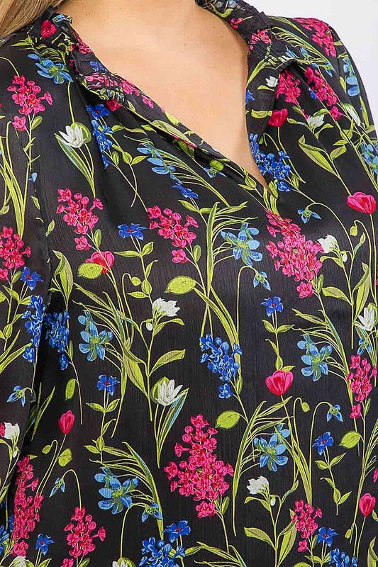 Long sleeve floral blouse with ruffle V-neck in vibrant colors by Sugarless, shown on a model with a relaxed fit.
