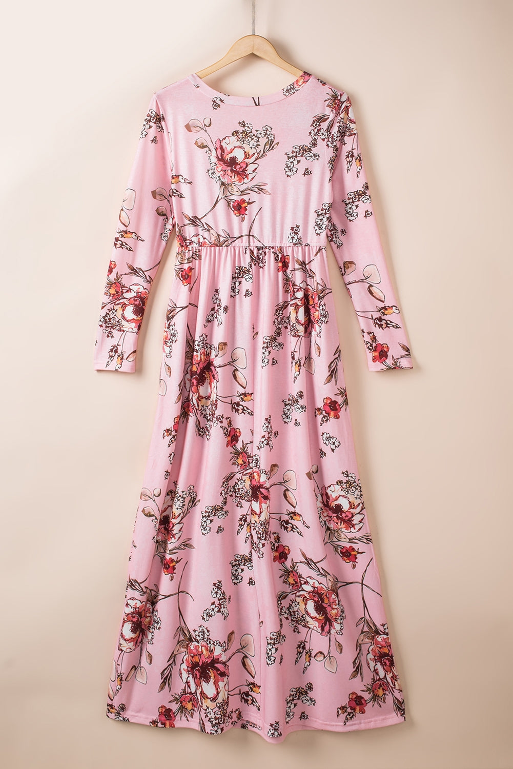 Pink faux wrap empire maxi dress with a flowing silhouette, featuring a V-neckline and long sleeves.