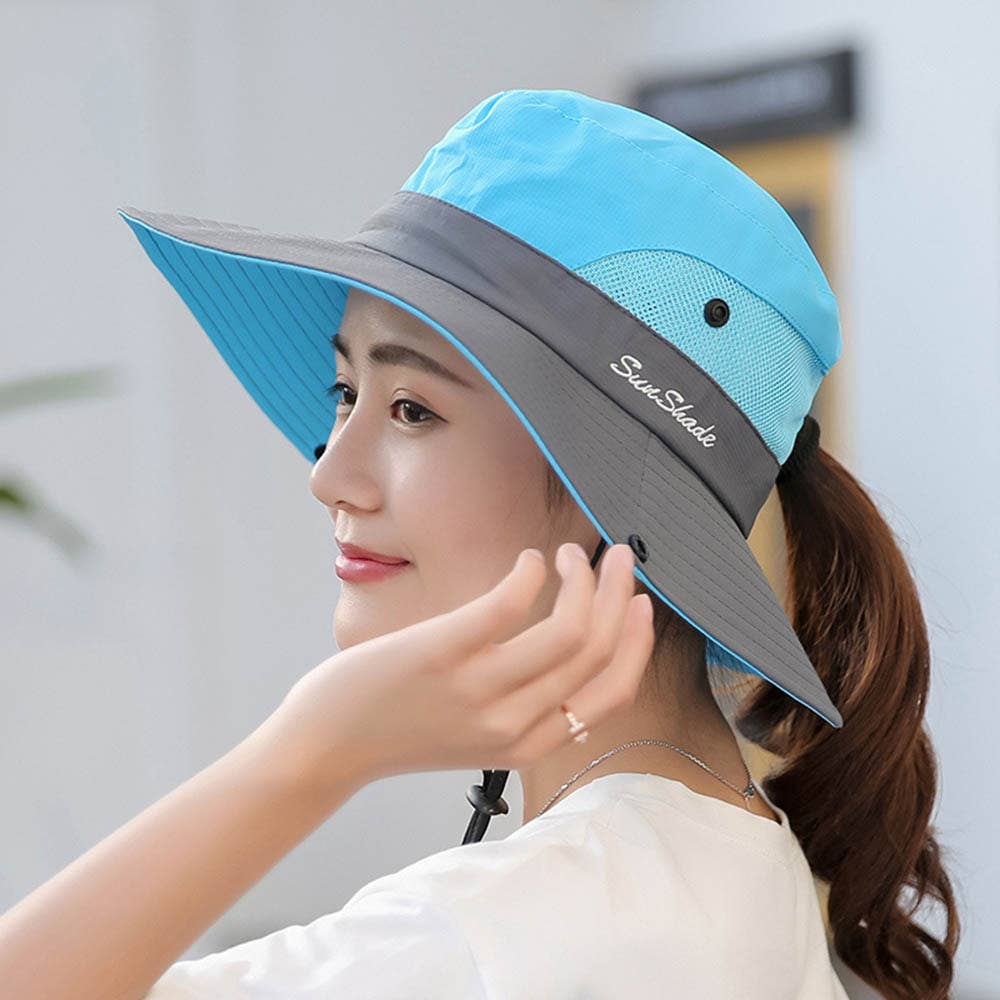 Pink women's UV protection hat with a wide brim and foldable design, featuring a ponytail opening for sun protection.