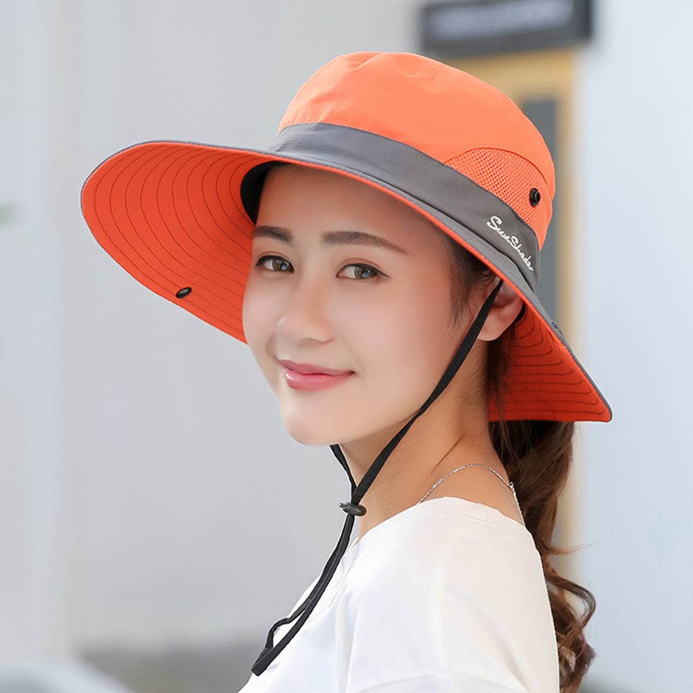 Pink women's UV protection hat with wide brim and foldable design, featuring a ponytail opening for sun protection.