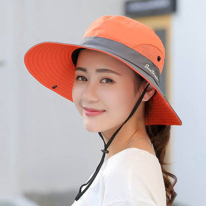 Pink women's UV protection hat with wide brim and foldable design, featuring a ponytail opening for sun protection.