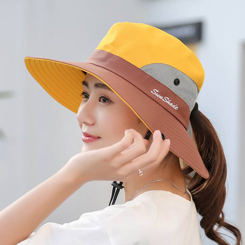 Pink women's UV protection sun hat with foldable wide brim and ponytail opening, by wholesalesir.